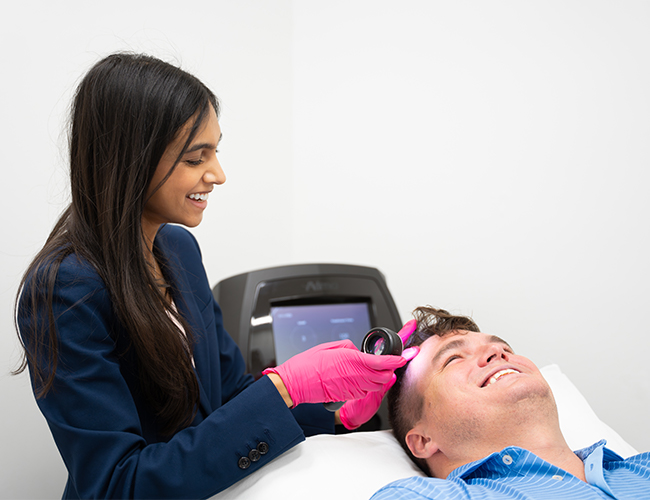 Dr. Ramani talking with patient while using AlmaTED machine